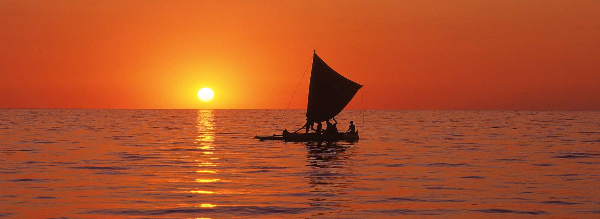 Fiery sunset with dhow on the water