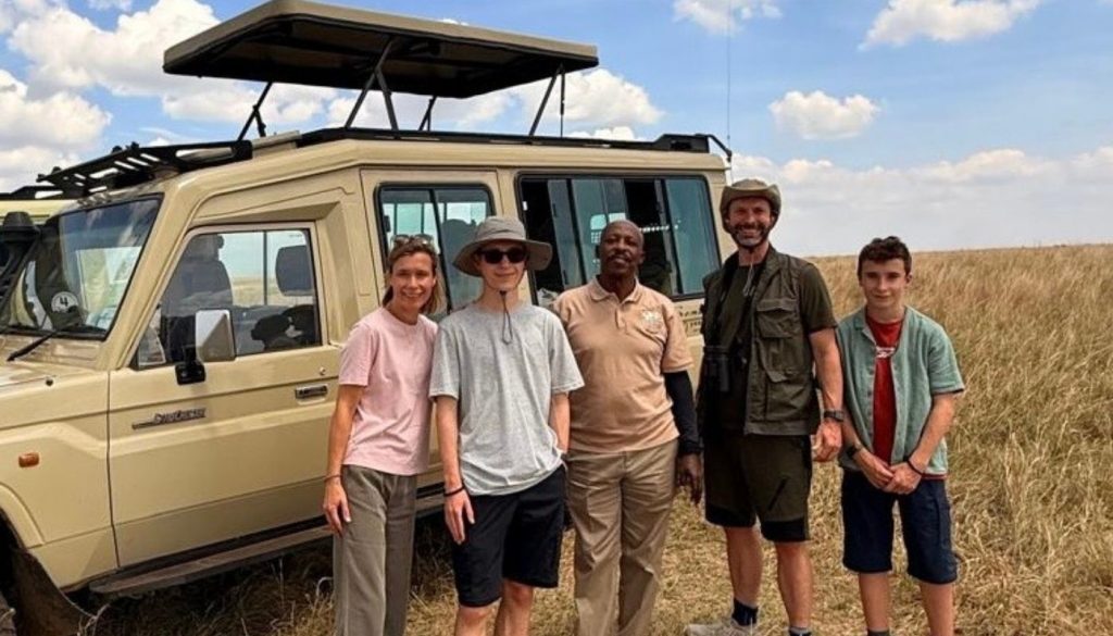 Liz and her family with Somak Driver Guide, Patrick outside his safari 4x4 vehicle while on a family safari in Kenya in August 2026. Liz and her family with Somak Driver Guide, Patrick outside his safari 4x4 vehicle while on a family safari in Kenya in August 2026